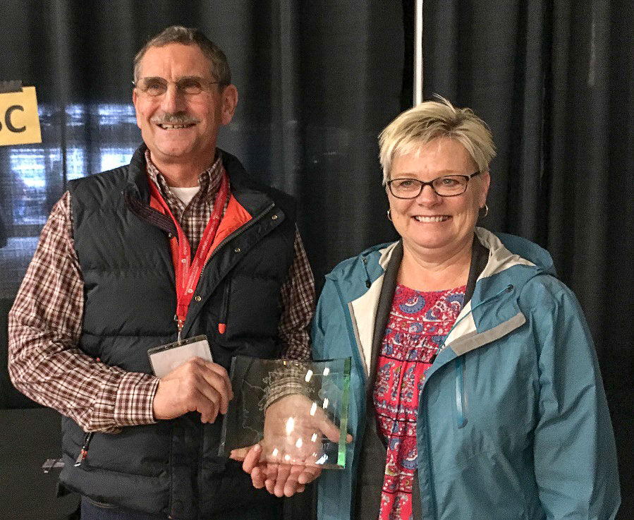 Randy Honcoop stands next to his wife, Leslie as he displays his 2017 Golden Berry Award.