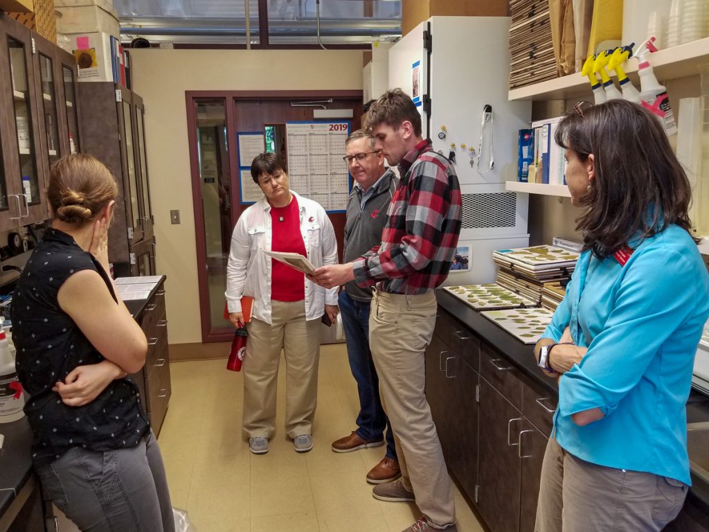 President Kirk and Noel Schulz view research in lab with graduate students.