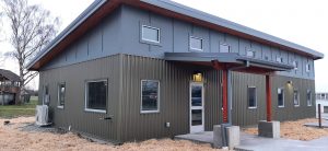 New construction building (steel skin with gray paneling above)