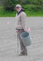 Jaime holding a bucket in a plowed field